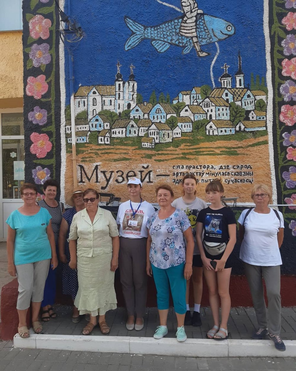Экскурсанты у здания Чашникского исторического музея с научным сотрудником Юлией Пуховицкой